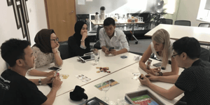 A group of people sat around a table playing Datopolis