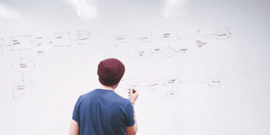 A man writing user journey on a whiteboard.